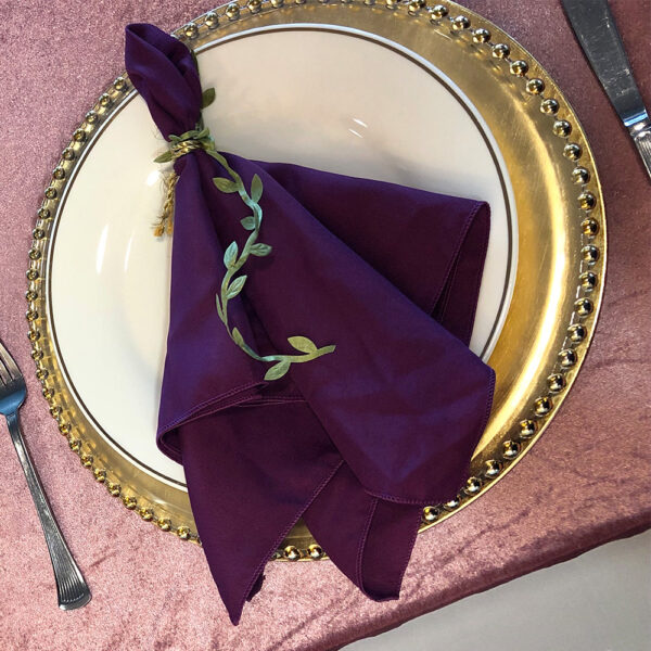 Elegant folded cloth napkins in various designs and colors, perfect for weddings, available for rent with professional folding service.