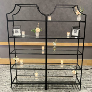 Modern black metal shelving unit with five glass shelves, perfect for displaying wedding photos, decor, or a stylish drink station.